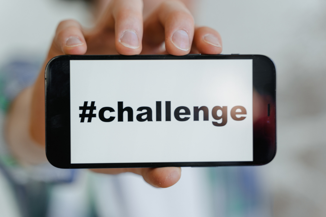 A smartphone screen displaying a branded hashtag challenge with user posts.