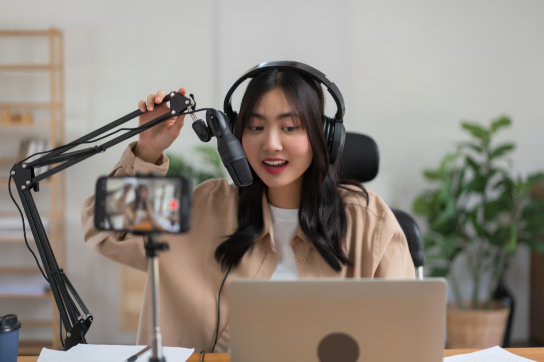 A young influencer livestreaming on TikTok with a smartphone, interacting with viewers through likes, comments, and emojis.