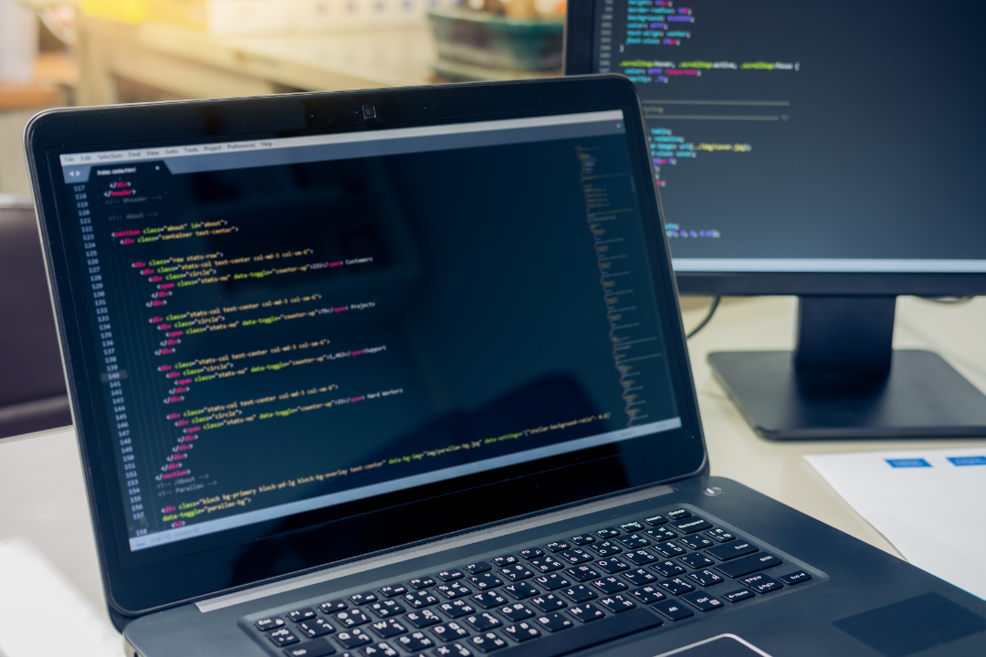 A digital illustration of a web developer coding on a laptop with a browser window open, surrounded by JavaScript-related icons like React, Node.js, and frontend design elements.