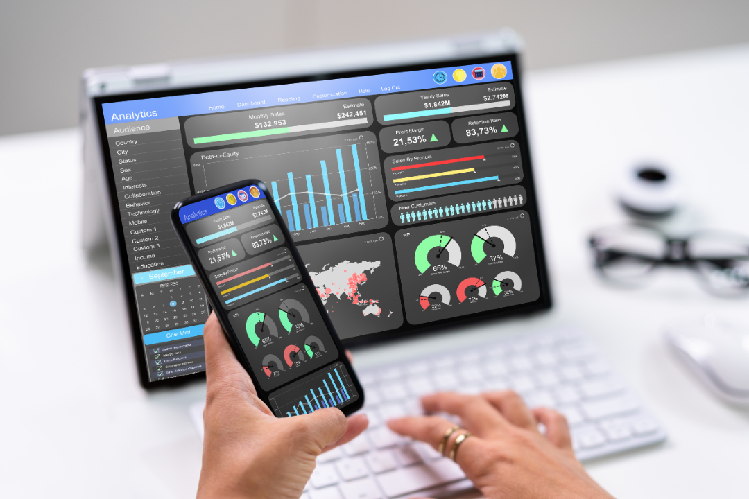 A sleek laptop showing a website performance dashboard with colorful graphs and SEO metrics in a professional workspace setting